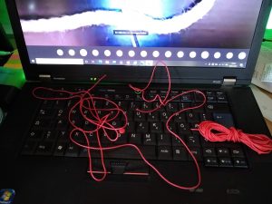 Ein Laptop mit einer roten Schnur, die auf der Tastatur liegt