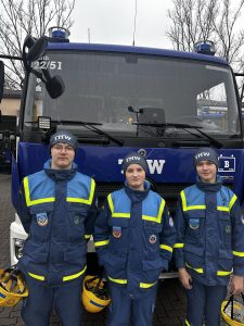 3 Jungehelfer vor einem THW-LKW