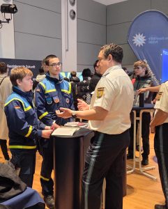 2 THW-Junghelfer am Stand der Polizei im Gespräch