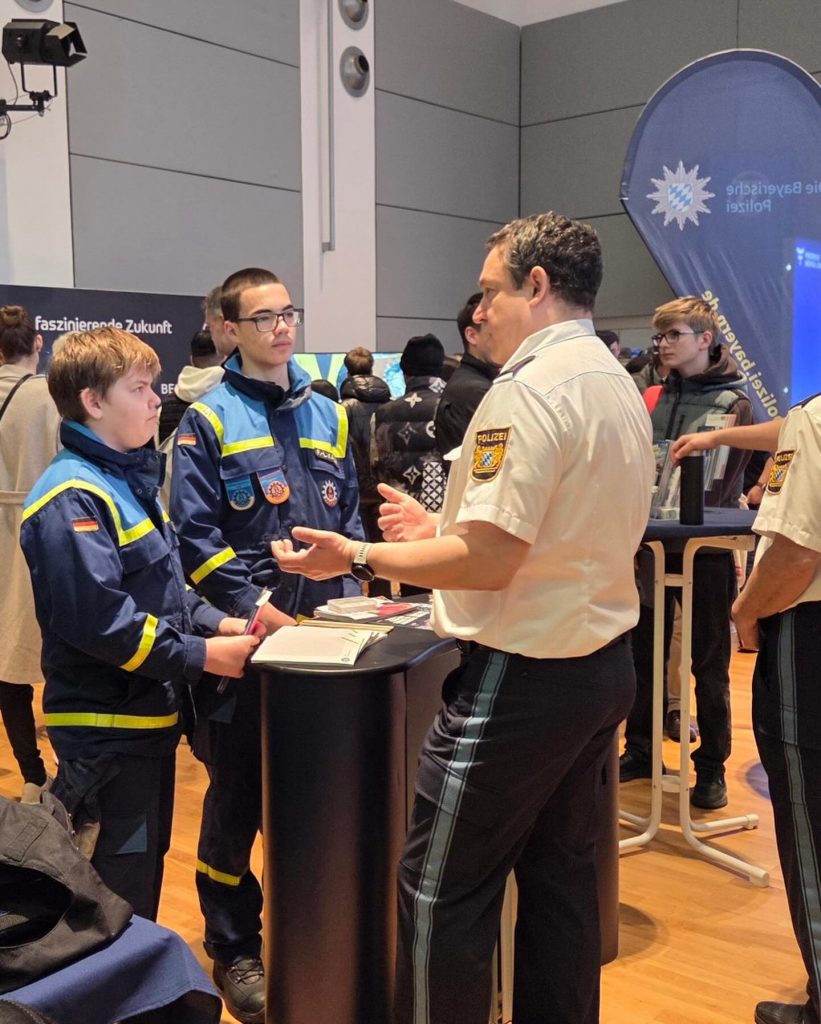 2 THW-Junghelfer am Stand der Polizei im Gespräch
