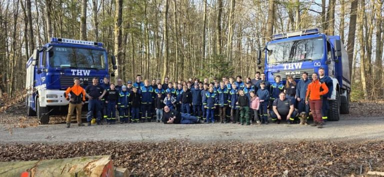 Gruppenbild vieler THW-Helfer im Wald