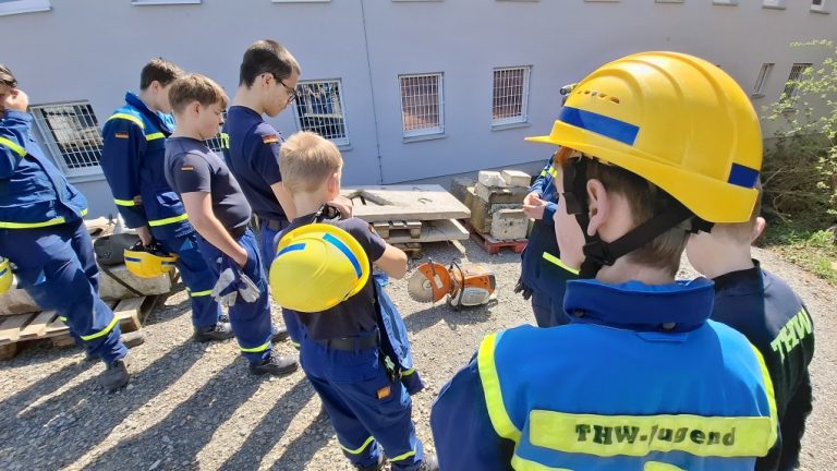 Junghelfer betrachten einen Trennschleifer