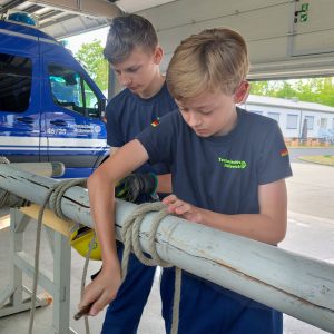 Zwei Junghelfer üben einen Mastwurf am Rundholze