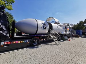Das SpaceBuzz sieht aus wie eine Rakete mit Klappen zum Einsteigen, die liegend auf einem LKW montiert wurde.