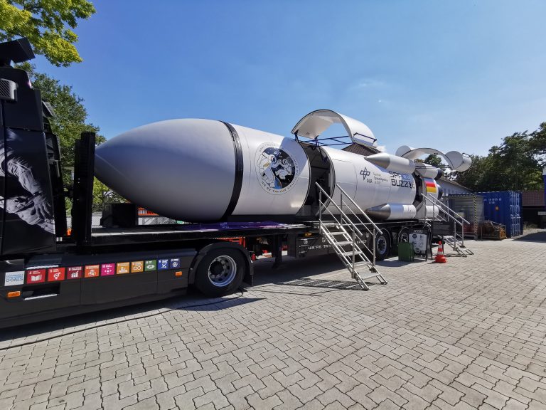 Das SpaceBuzz sieht aus wie eine Rakete mit Klappen zum Einsteigen, die liegend auf einem LKW montiert wurde.